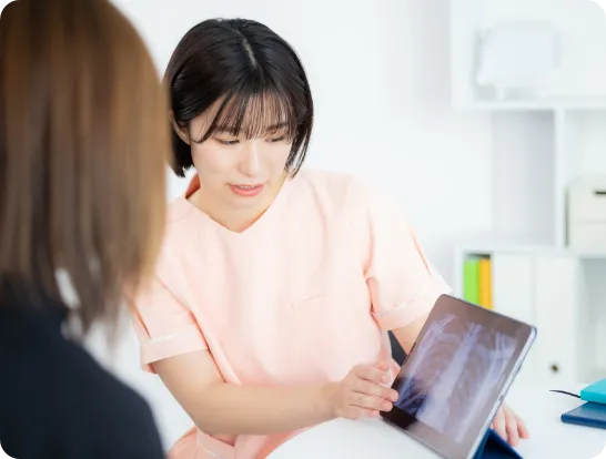 タブレットでレントゲン画像を説明するスタッフ